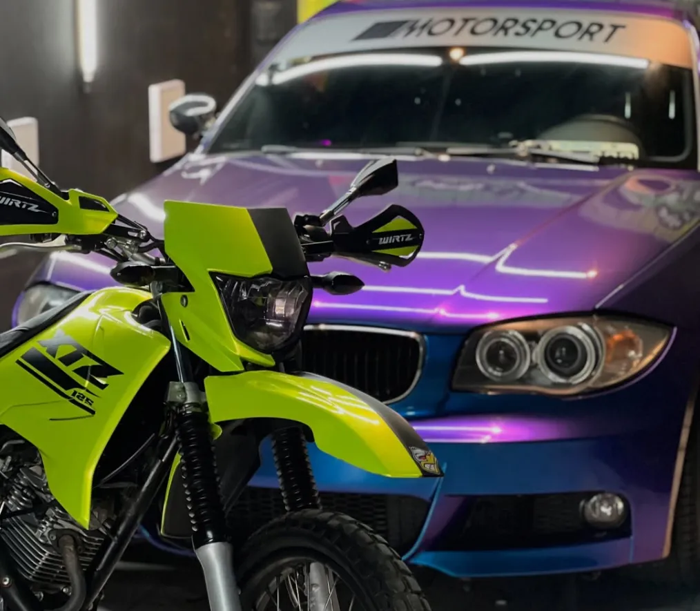BMW con ploteo vehicular violeta junto a una moto con diseño personalizado